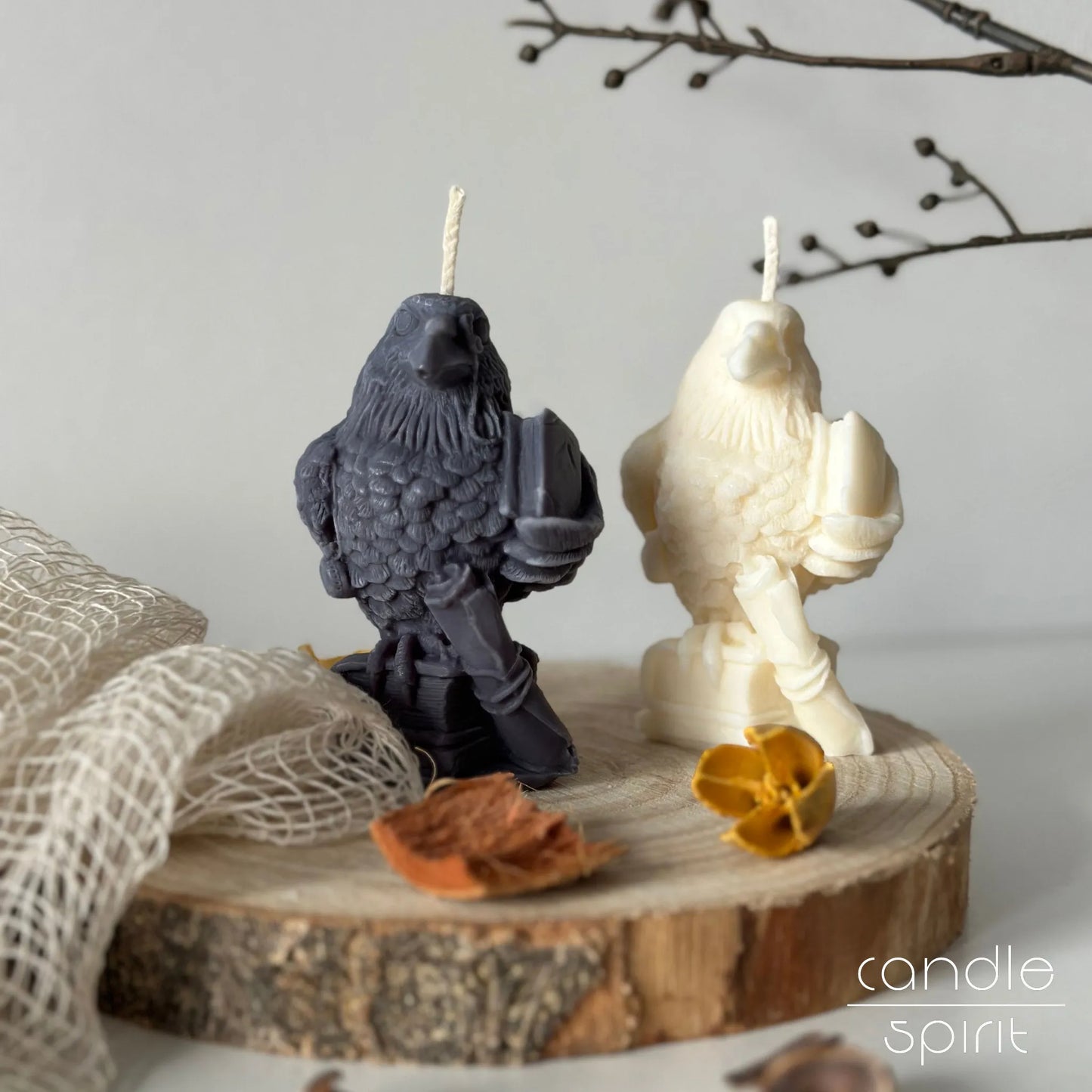 Two raven candles, one white, one gray, on a fall background - gothic home accent, dark academia aesthetic, and Halloween gift