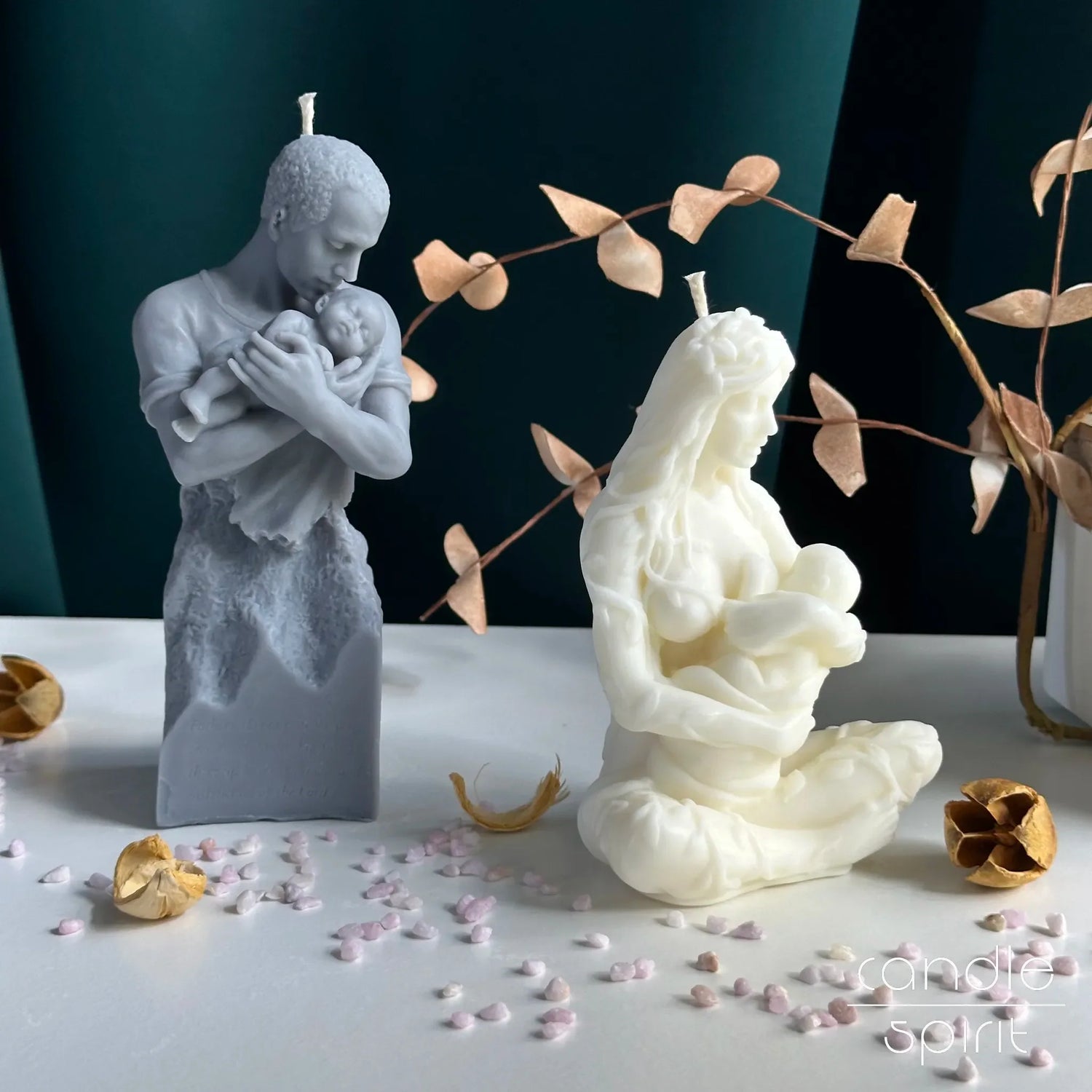 Two scented gray and white candle sculptures of a man holding a child and a woman with a child - unique Mother's Day and Father's Day gift