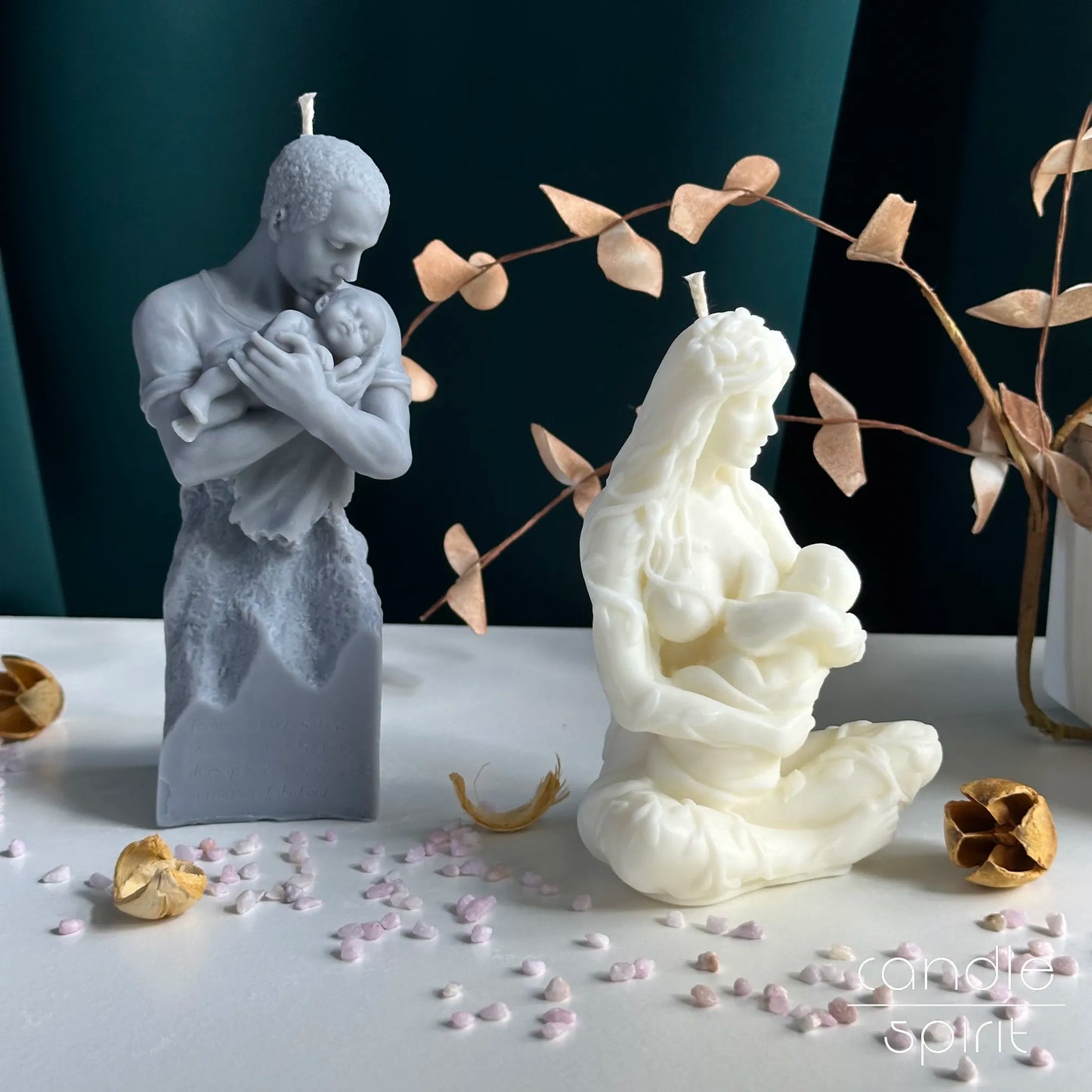 Two sculptural candles of a man holding a child and a woman with a child - first Father's Day and Mother's Day gifts for new moms and dads.