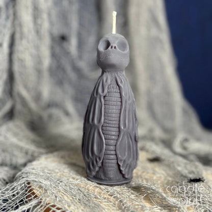 Gray skeleton candle on a textured fabric background - Halloween home decor