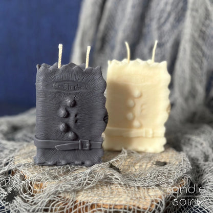 Scented gray and white monster book candles on a textured surface with a blue background - Halloween decor and perfect gift for book lovers