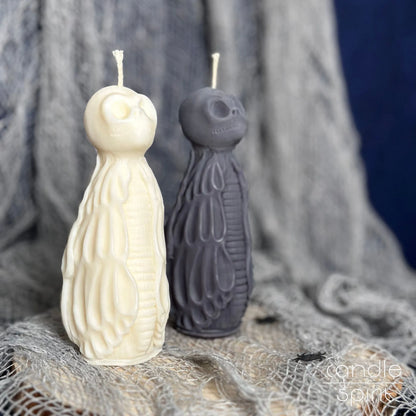 Two scented Halloween skull candles, one white and one gray, on a textured fabric background - unique gift for gothic lovers, rockers, and bikers.