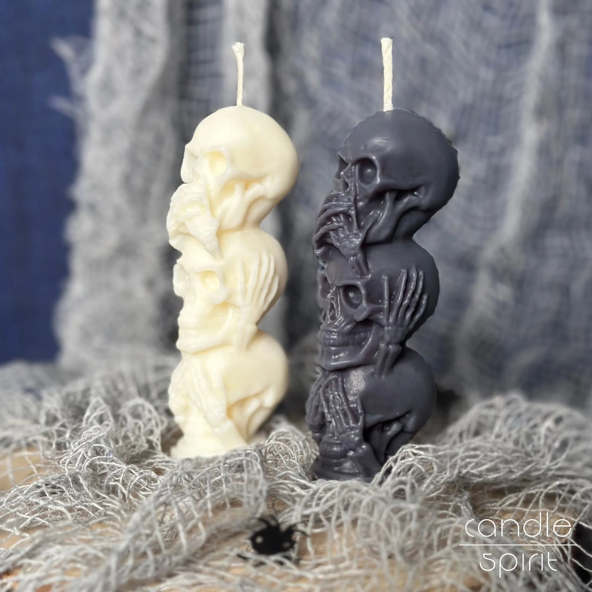 Two fall scented skull candles, one white and one gray, on unique Halloween decorations.