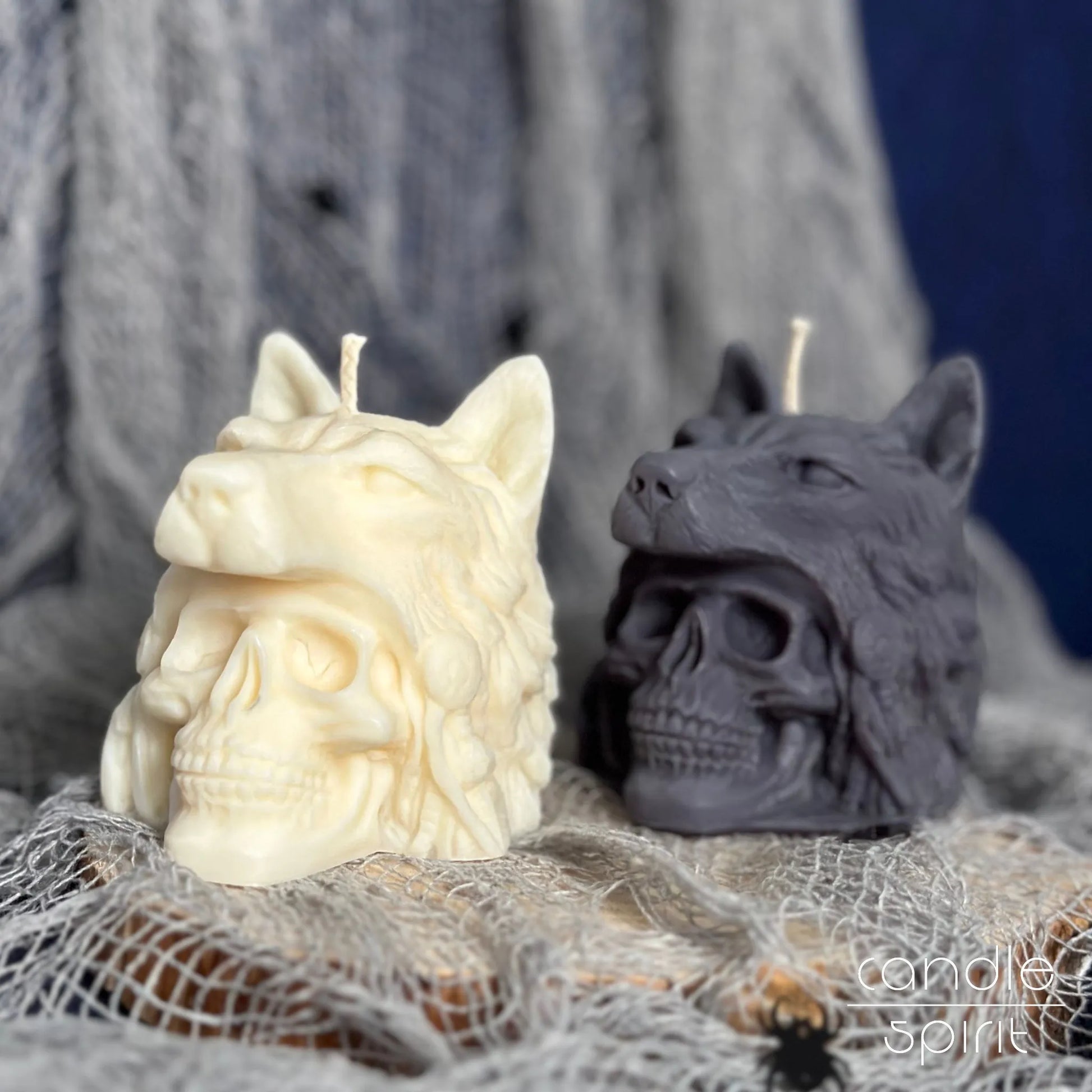 Two scented wolf-headed skull candles, one white and one gray, with Halloween decorations.Spooky home decor for skull lovers.